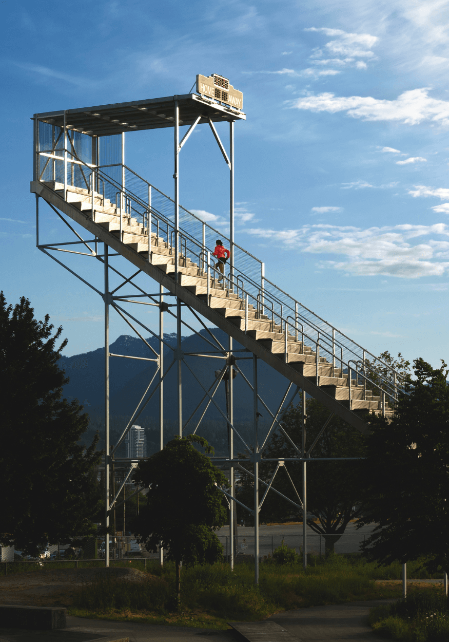 Runner climbing outdoor stairs with mountains in the background
